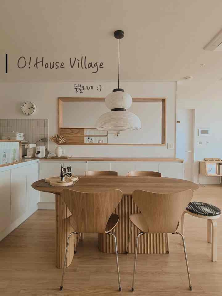 Natural wood tone and white walled dining room featuring modern pendant light and dining chairs with cozy atmosphere