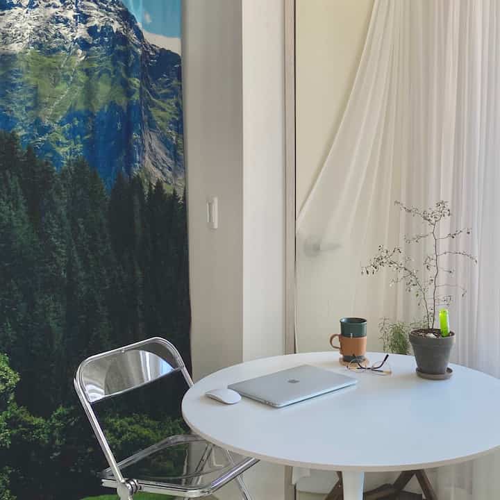White transparent sheer curtain with round table, used as a curtain to hide outdoor unit space, cozy veranda home office area