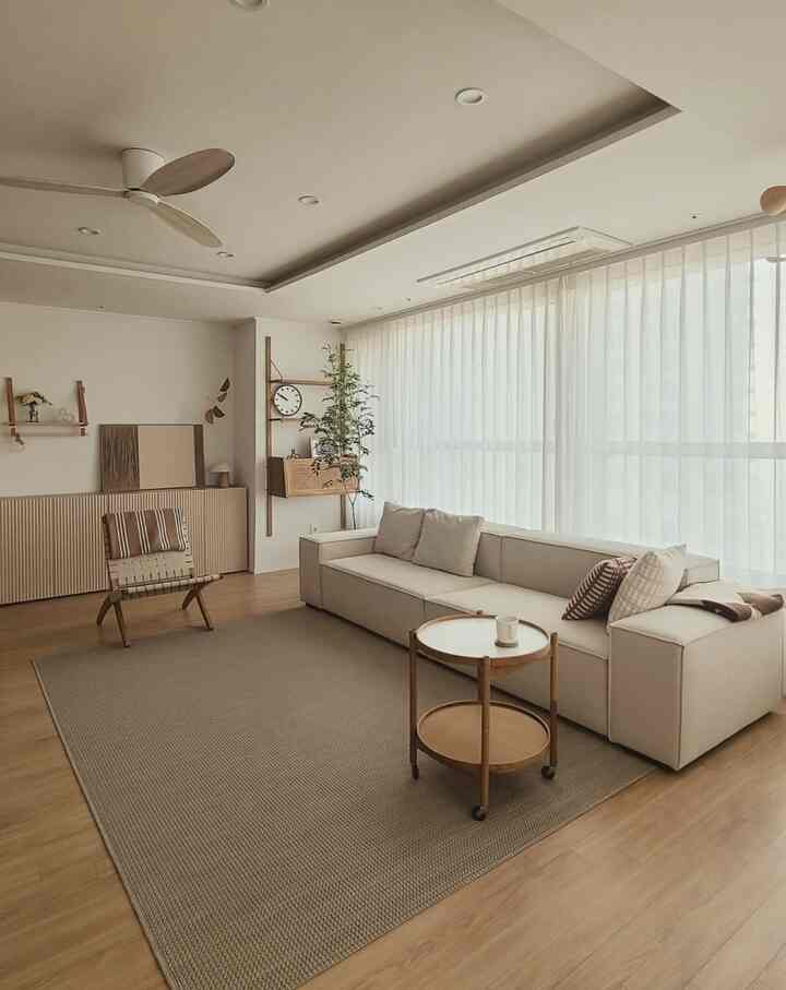 Beige and wood-tone living room featuring a cream sofa and wooden side table in a simple, calm setting