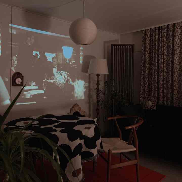 Vintage-style living room with floor lamp and floral curtains, featuring a cozy home cinema atmosphere