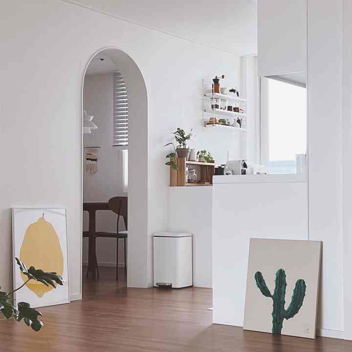 White and wood tone kitchen space featuring natural elements with a simple and airy atmosphere