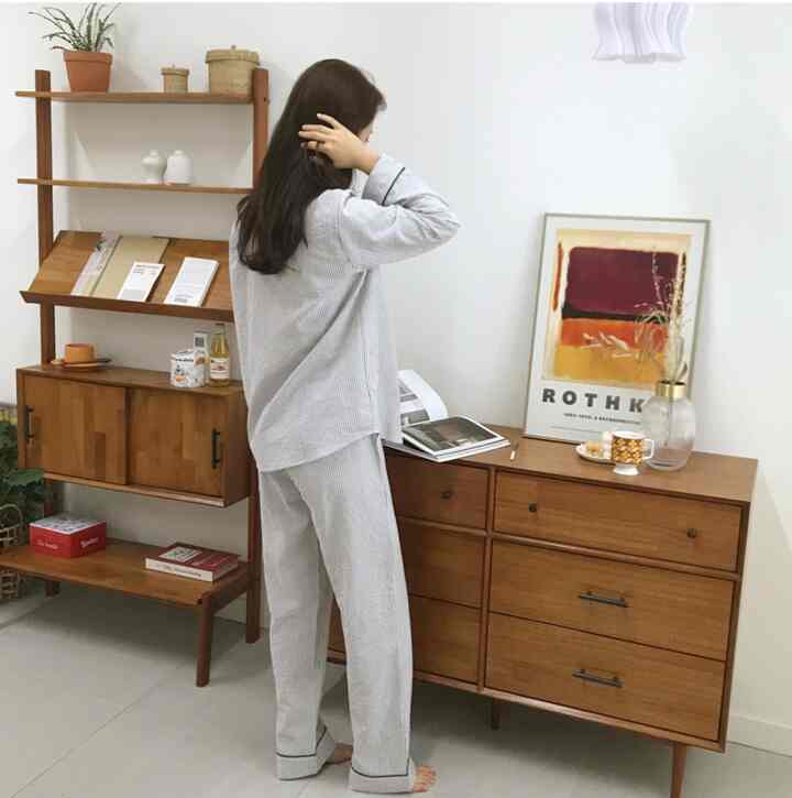 White background living space featuring wood tone dresser and cabinet in vintage style home gallery with cozy atmosphere