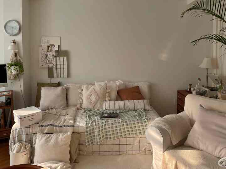 Beige and ivory toned living room featuring white sofa and beige armchair with a warm and cozy atmosphere