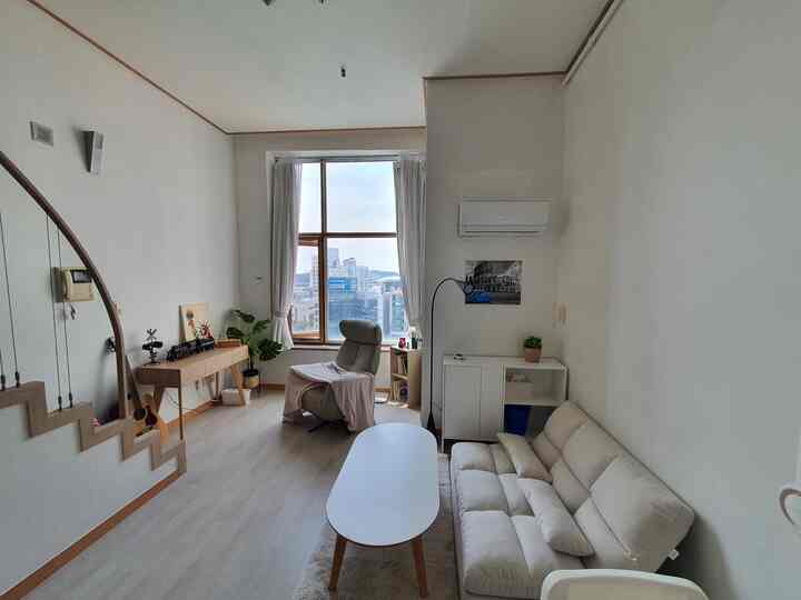 White and light brown toned studio living room featuring sofa and coffee table with a simple natural modern atmosphere