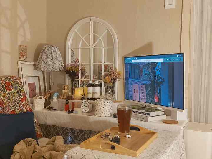 白を基調としたリビング、フロアランプと花柄のソファが配置された雰囲気のあるカフェ風インテリア