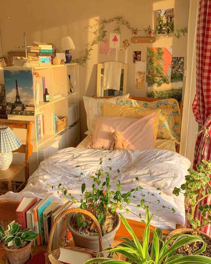 ホワイトとブラウン、レッドの色調が調和した寝室、木製ベッドと多くの植物が配置された温かみのあるヴィンテージな雰囲気のインテリア