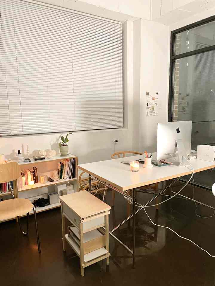 White and brown toned home office space featuring a desk, computer, and storage cabinet in a clean, simple workspace
