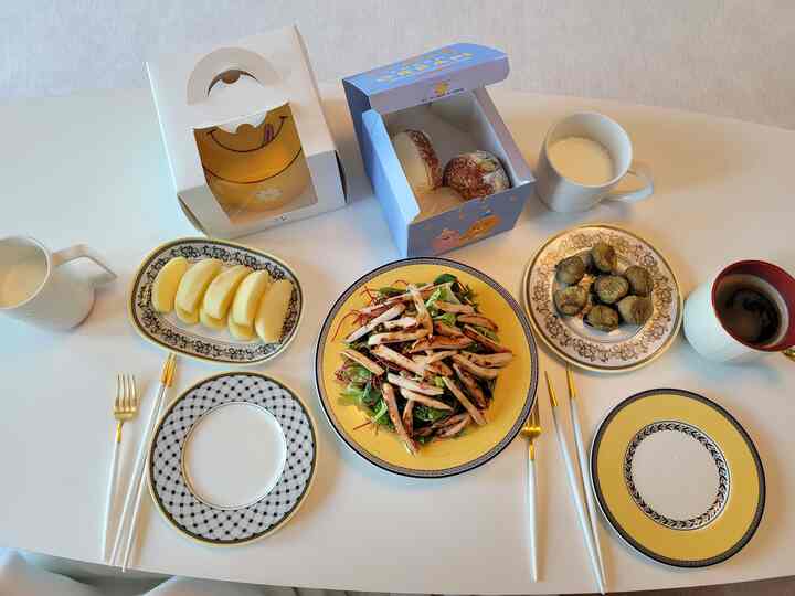 White table dining space featuring gold forks, plates, and cutlery with a home cafe atmosphere