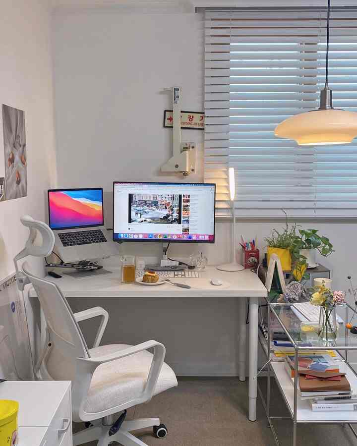 ホワイトトーンのホームオフィス、デスクとオフィスチェア、ミニマルなスタイルのコンピュータ環境が配置された印象的な空間