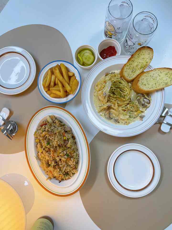Natural beige-toned dining table featuring plates, bowls, and glassware with a cozy home cafe atmosphere