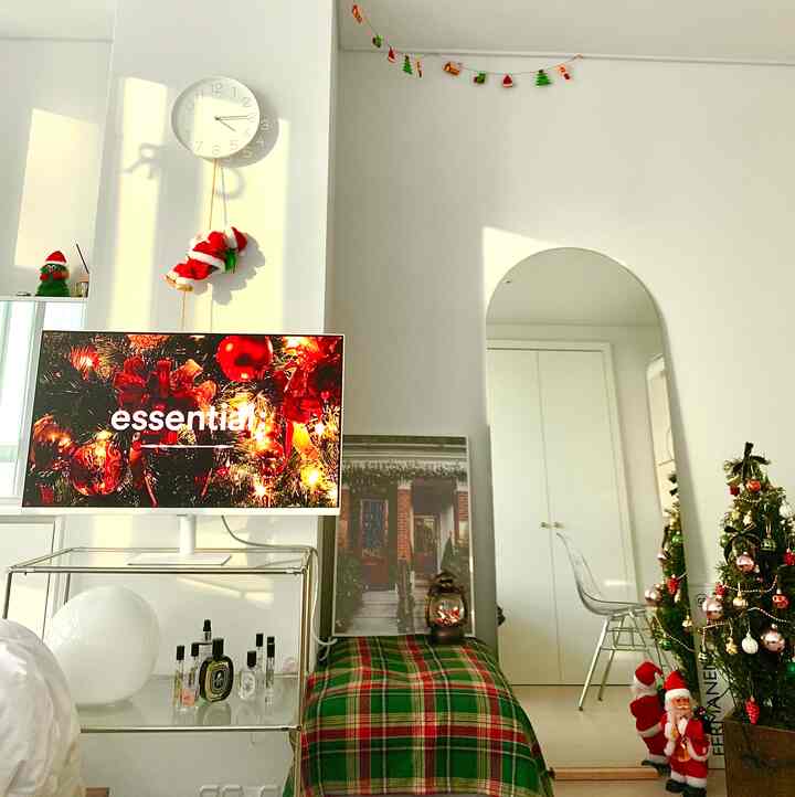 白を基調とした寝室、クリスマスツリーとサンタ人形、アーチ型の鏡が配置された雰囲気のあるインテリア
