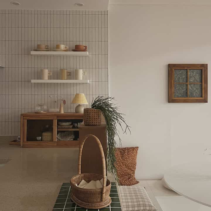 Soft beige natural wood tone kitchen space featuring shelves with dishware and rattan decor creating a cozy atmosphere