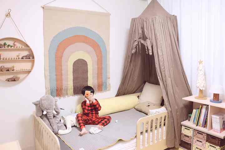 Brown-toned kids' room featuring natural wood bed with canopy, toys, and wall shelf in a cozy setting