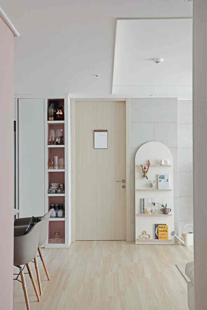 Beige and wood-tone living room featuring magazine rack and dining chairs with a simple and cozy atmosphere