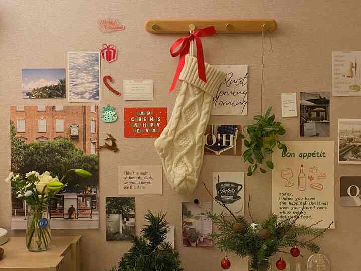 温かみのあるベージュ色の壁にクリスマス装飾と花瓶が配された雰囲気のあるウォールデコ空間