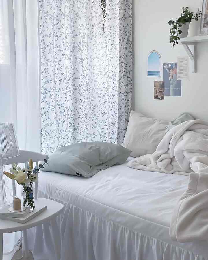 White and blue toned 6-tatami bedroom featuring a neat bed and floral curtains with a natural modern interior