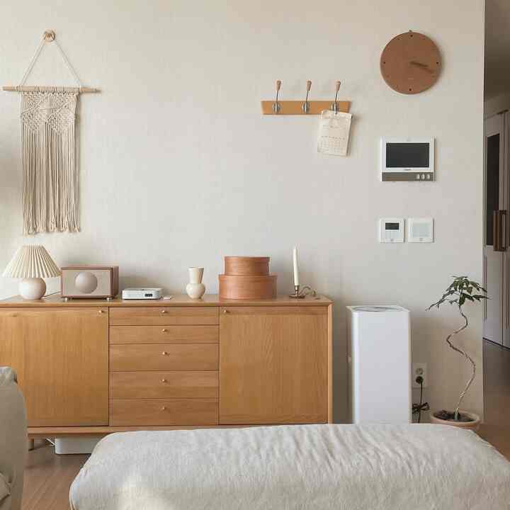 Soft natural tone living room featuring wood tone cabinet and simple decor creating a cozy atmosphere