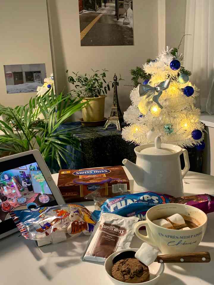 White and blue toned studio apartment featuring a Christmas tree and home cafe setup with cozy atmosphere