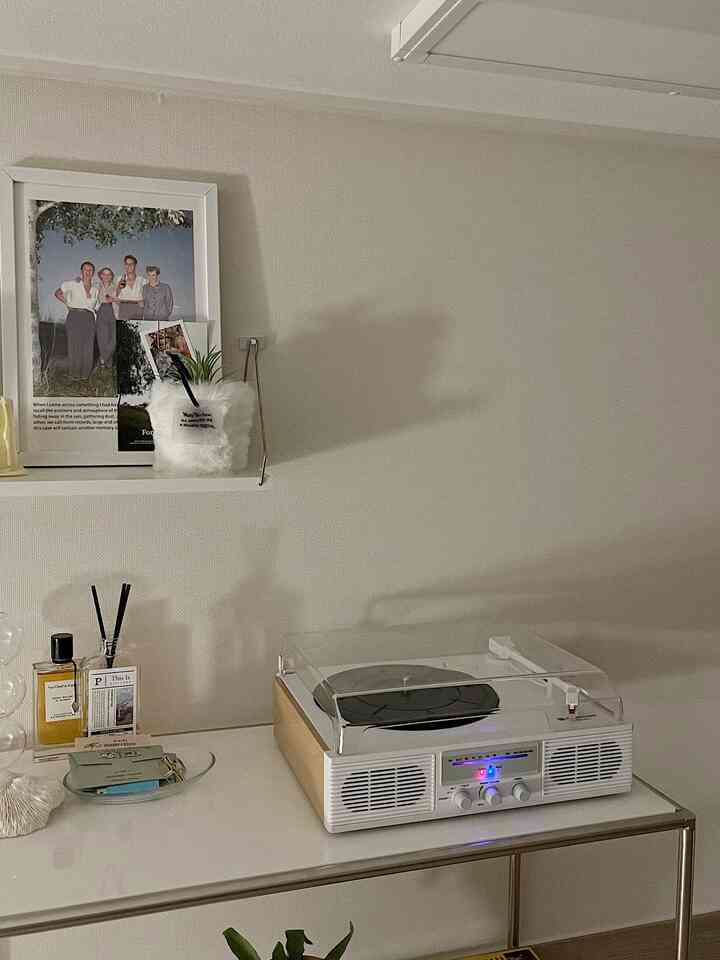 White tone studio apartment featuring a turntable and picture frames with a simple modern atmosphere