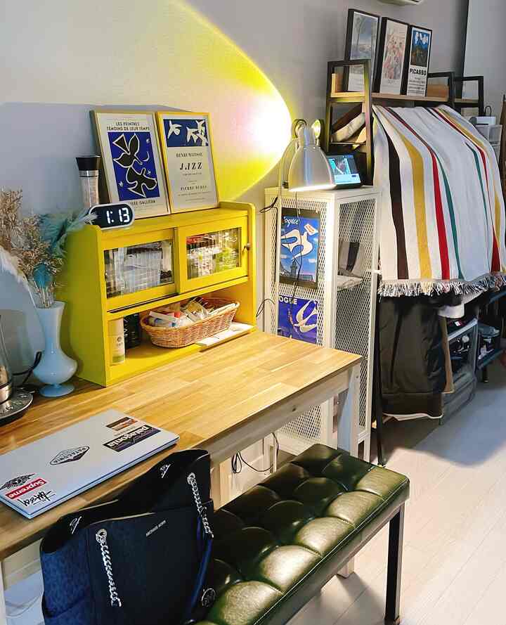 黄色のムードライトが灯る木製の作業台と額縁が配置された雰囲気のある作業室