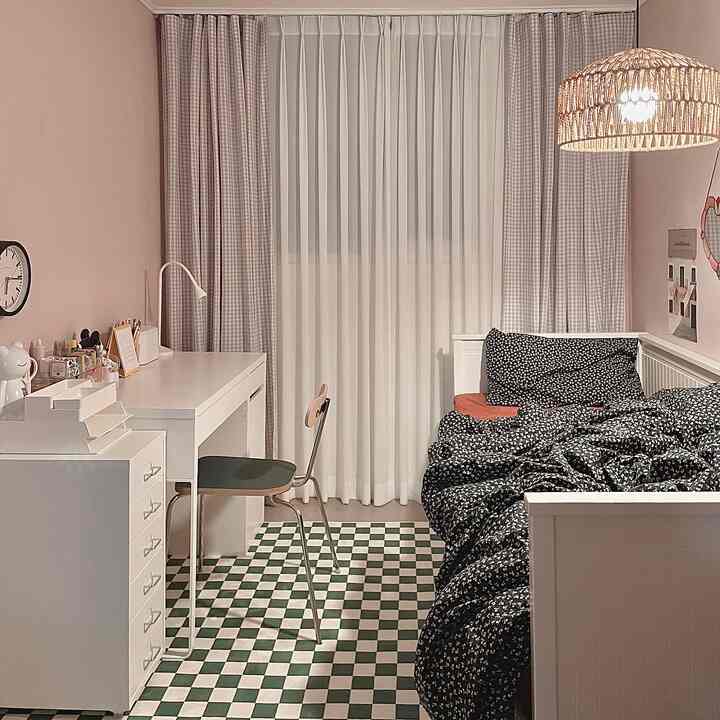 柔らかな白と緑の色調が特徴的な子供部屋、机とベッドが配置された温かみのあるインテリア