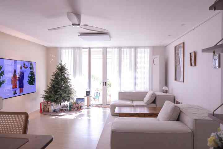 ホワイトとウッドトーンのリビング、モジュールソファとクリスマスツリーが配置された明るく落ち着いた空間