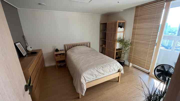 Minimal bedroom with natural beige and wood tones featuring bamboo furniture and calm atmosphere