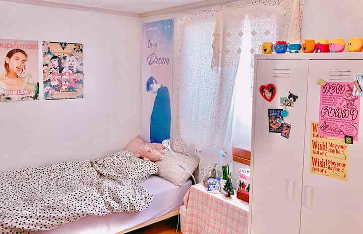 Bright white-toned bedroom featuring a polka-dot duvet cover and a closet decorated with colorful toys creating a cozy vibe