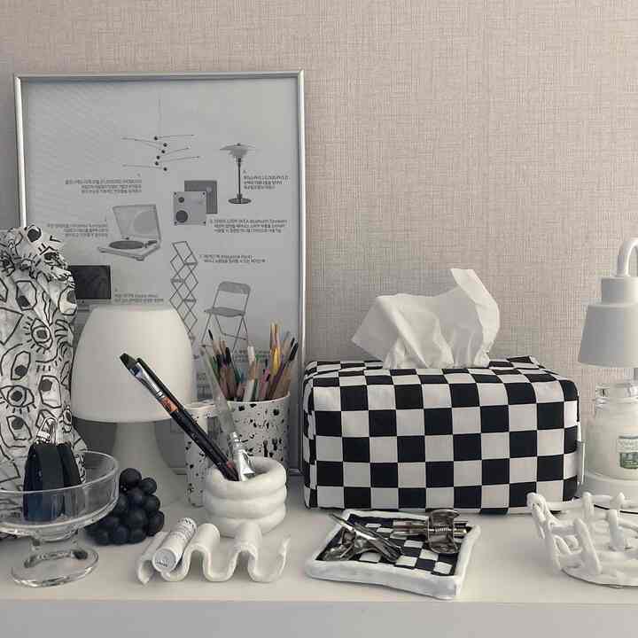 White and black toned Mid-Century Modern space featuring checkerboard tissue box and table lamp in a harmonious decor setting
