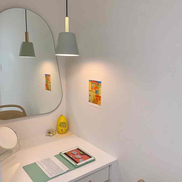 白を基調としたホームオフィス、ミニマルな机とiPad、ペンダントライトが配置されたシンプルで清潔感のあるインテリア