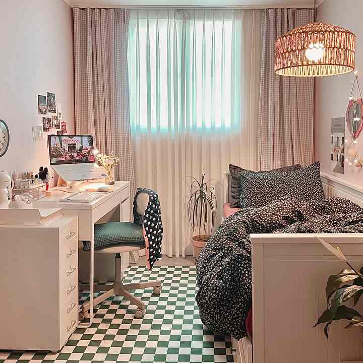 白と緑のトーンの狭い子供部屋、机とベッドが配置された落ち着いた雰囲気のインテリア