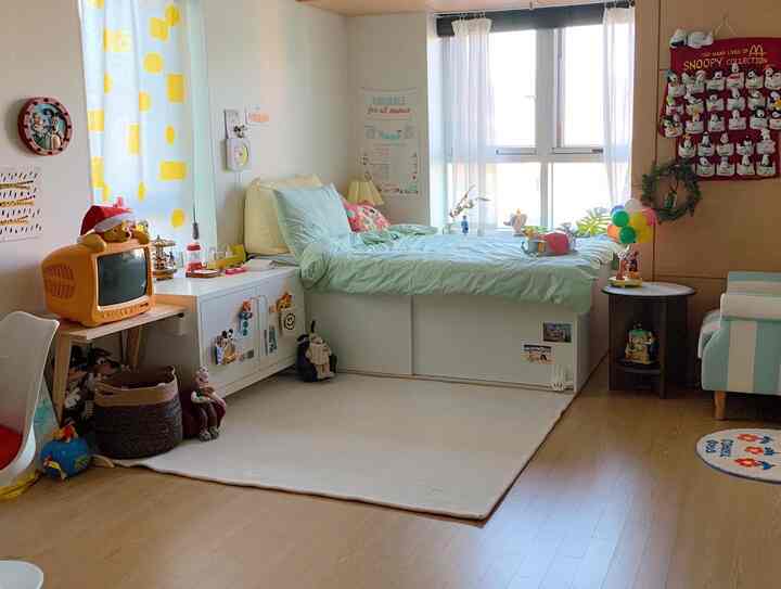 A cozy baby bedroom featuring white and mint tones, storage bed, and child-friendly decorations in a bright natural light setting
