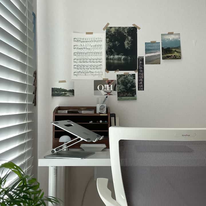 Modern compact home office featuring white desk and brown wooden organizer with clean layout and natural decor