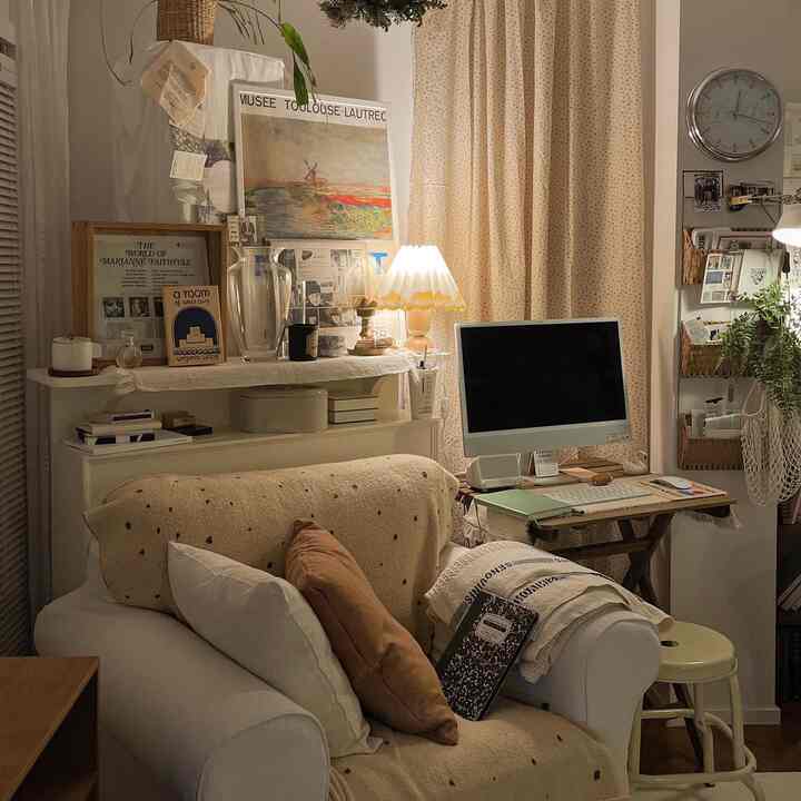 Cozy living room in warm beige and natural tones featuring a single sofa and computer desk, creating a comfortable home office atmosphere