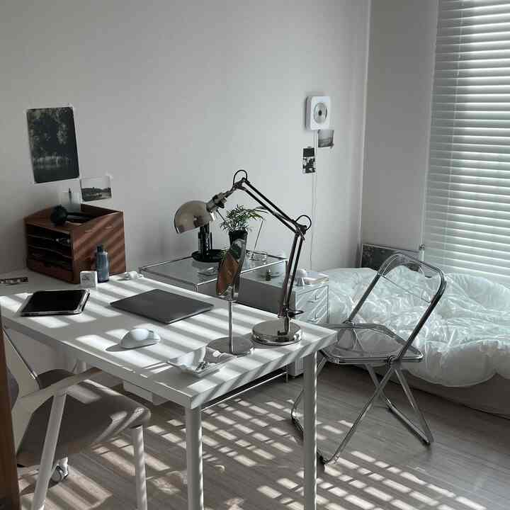 White and gray toned compact room for single household with a combined home office and bedroom setup