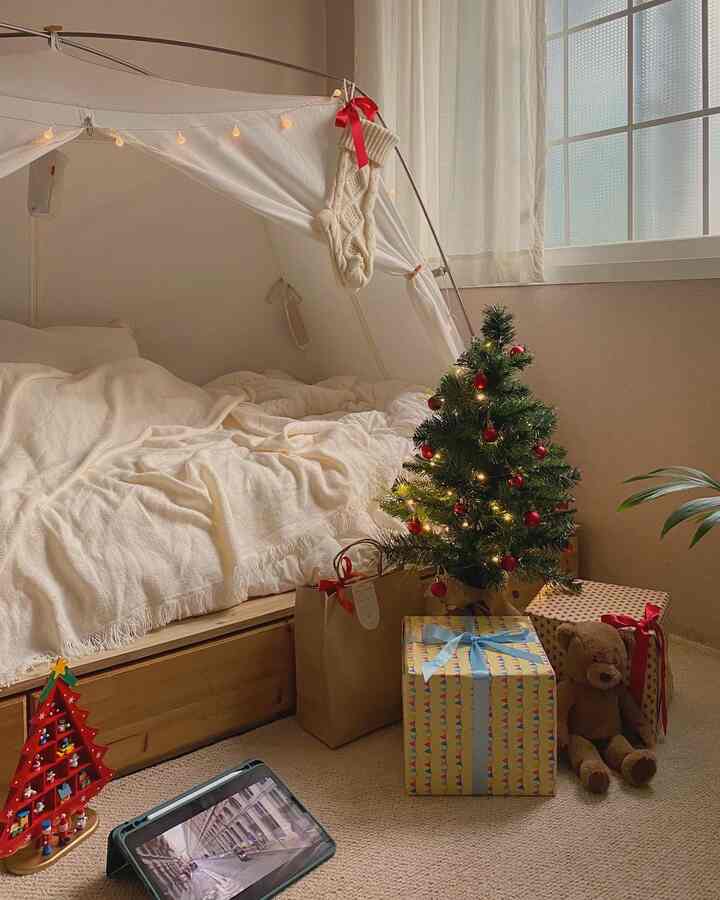ベージュとクリーム色の調和が取れた寝室、クリスマスツリーとプレゼントが配置された雰囲気のある空間