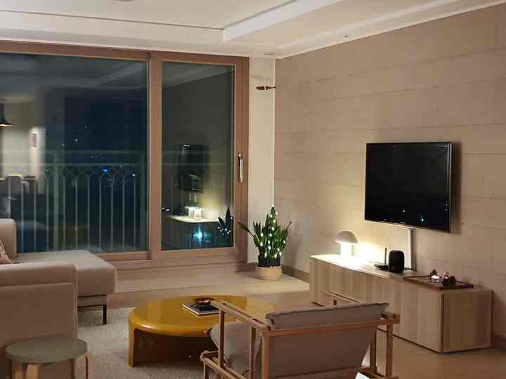 Natural color beige toned living room featuring a yellow coffee table and wooden furniture creating a cozy atmosphere