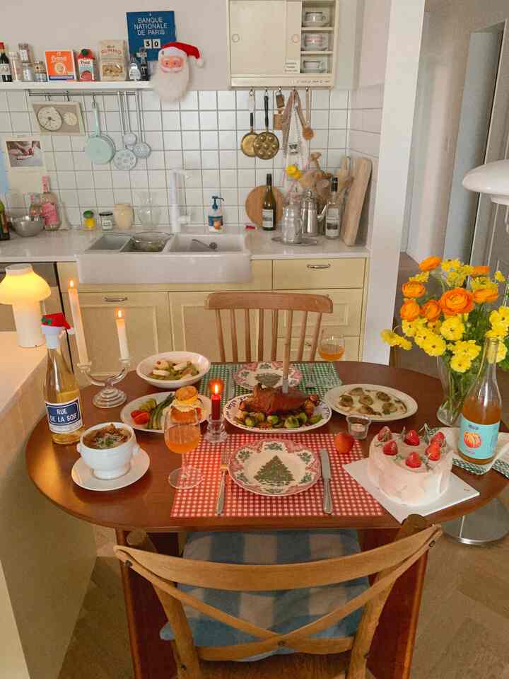 温かみのある木目調と赤・黄色のアクセントがあるキッチンとダイニング、クリスマスのホームパーティー空間