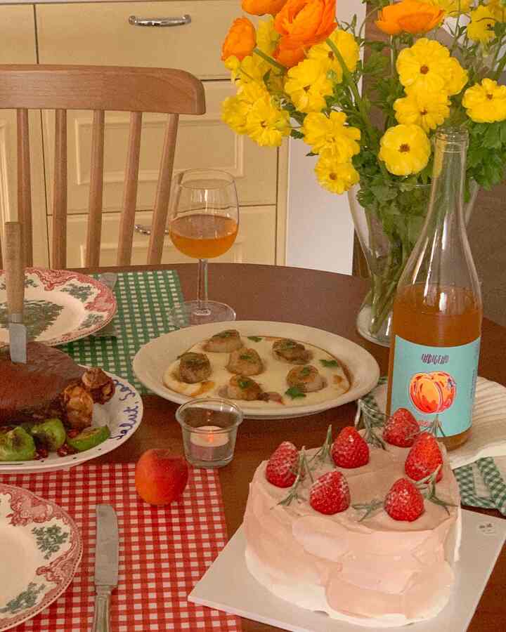 赤と緑の彩りのダイニングテーブル、クリスマスの飾りと料理が配置された暖かいホームパーティーのインテリア