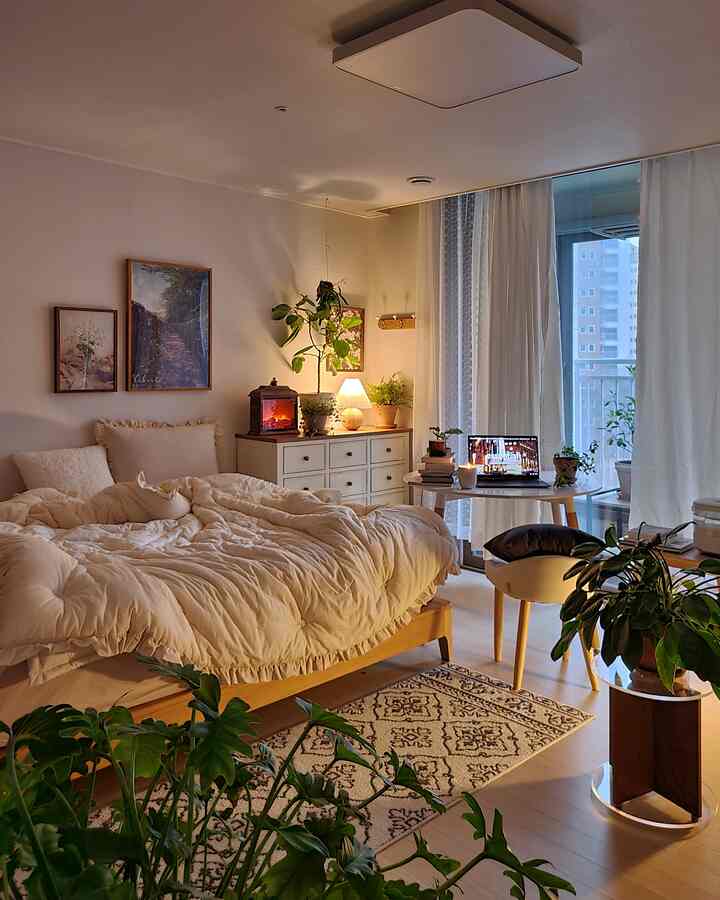 温かみのある木目調とナチュラルカラーの寝室、ベッドと植物、照明が調和した雰囲気のあるインテリア