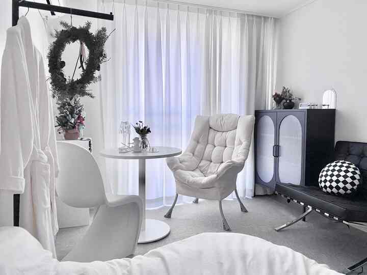 White and black toned bedroom featuring a round table and armchair with a modern atmosphere