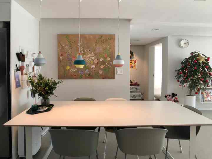 ホワイトトーンの6畳ダイニング、モダンな空間に大きな白いダイニングテーブルと椅子、花柄の絵とペンダントライトが配置された印象的なインテリア