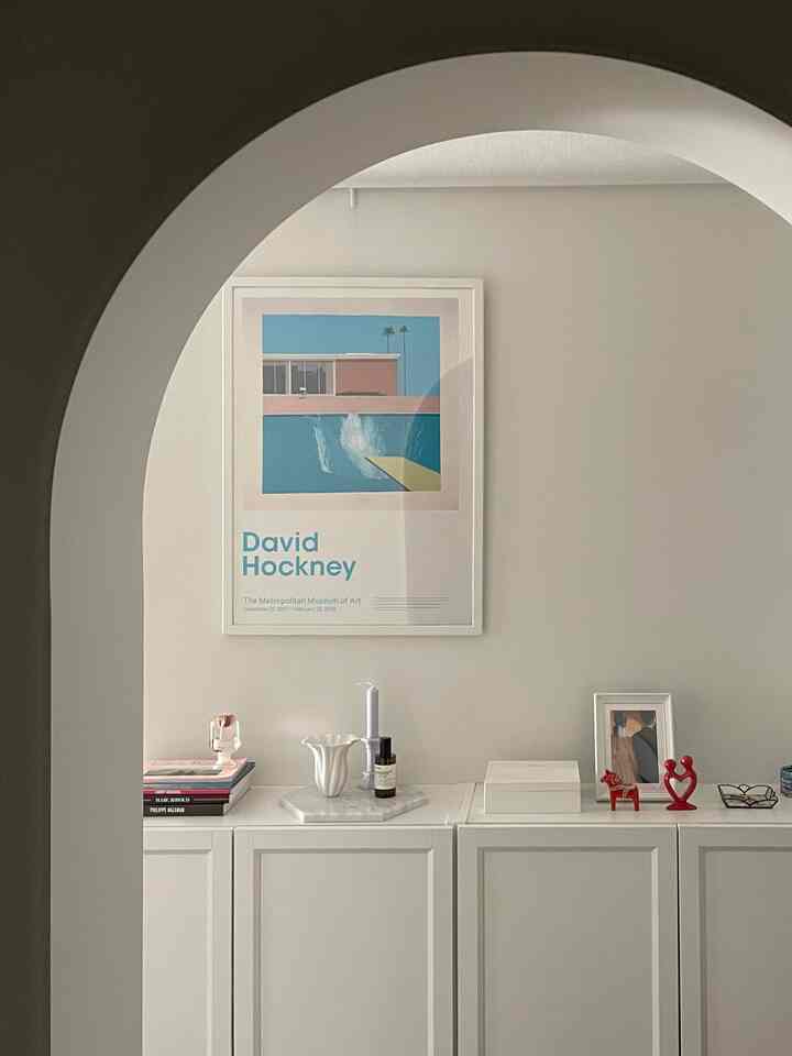 柔らかなホワイトトーンのアーチ型入口とキャビネットが配置されたシンプルで清潔感のある空間