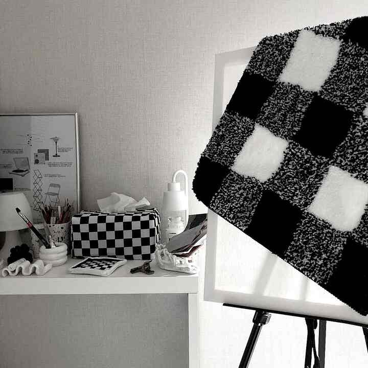 Black and white monotone desk space featuring checkered accessories and organized small items, creating a tidy work area