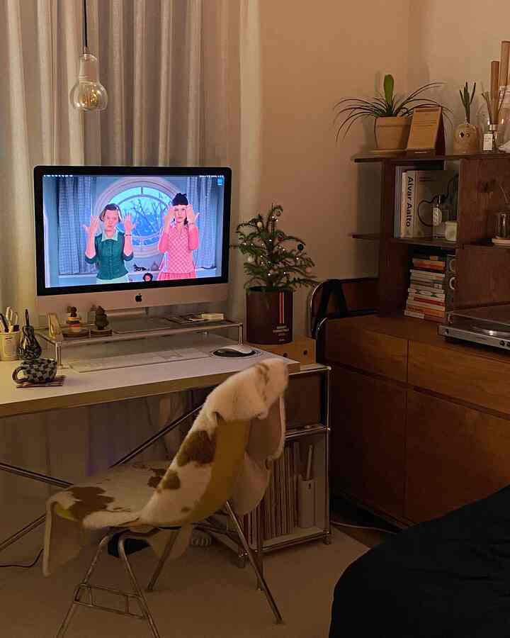 Beige and brown toned home office featuring a computer desk and a pet cat in a cozy workspace