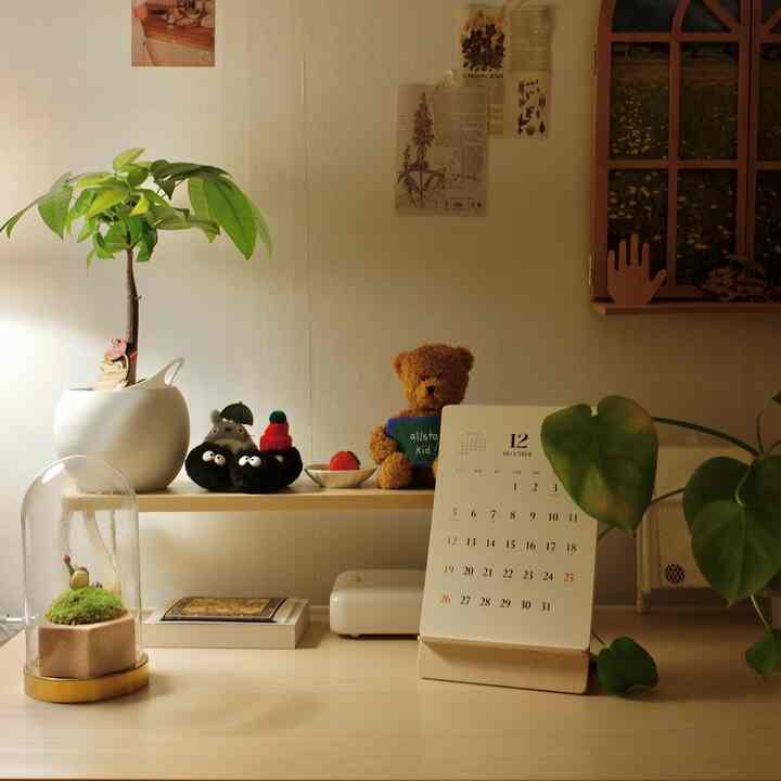 ナチュラルな色調のデスクと植物が配置された印象的なホームオフィス空間