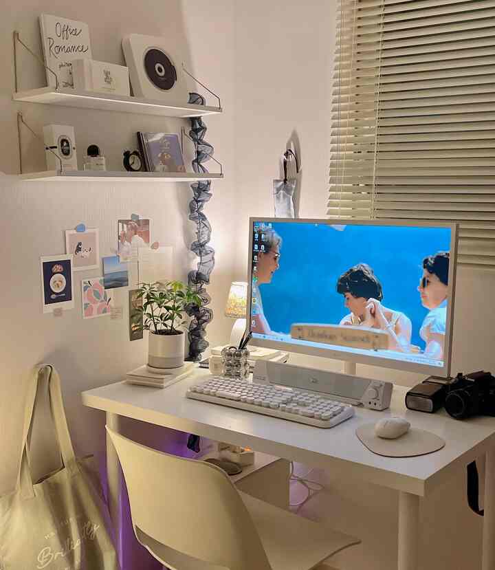 ホワイトとライトグレーのトーンでまとめられたホームオフィス、シンプルで整頓されたデスクとモニターが配置された印象的なインテリア