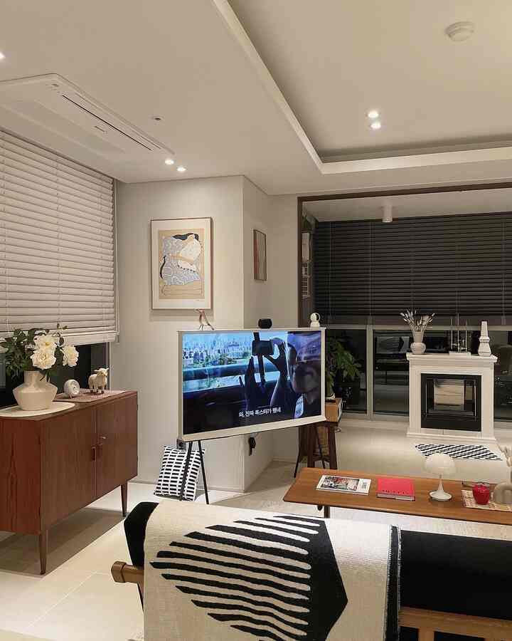 White and wood tone living room featuring mid-century modern furniture, The Serif TV and fireplace creating a vintage ambiance