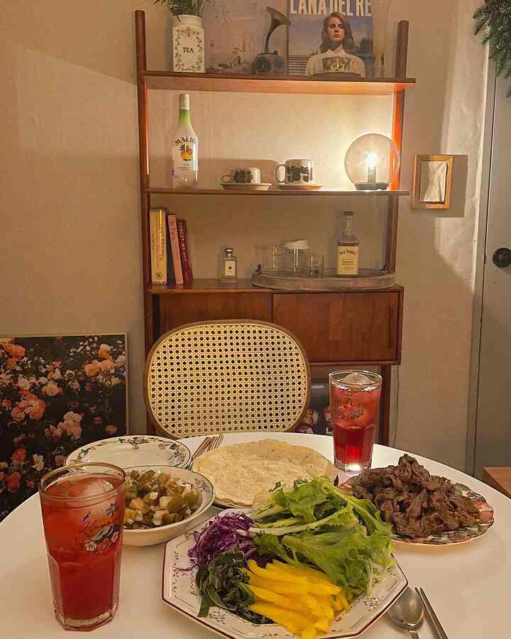 Warm brown and white toned living room featuring a rattan chair and round table with drinks and food creating a cozy home cafe atmosphere