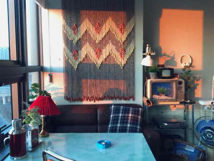 A red and brown toned living room featuring a brown leather sofa and wall decor creating a cozy atmosphere